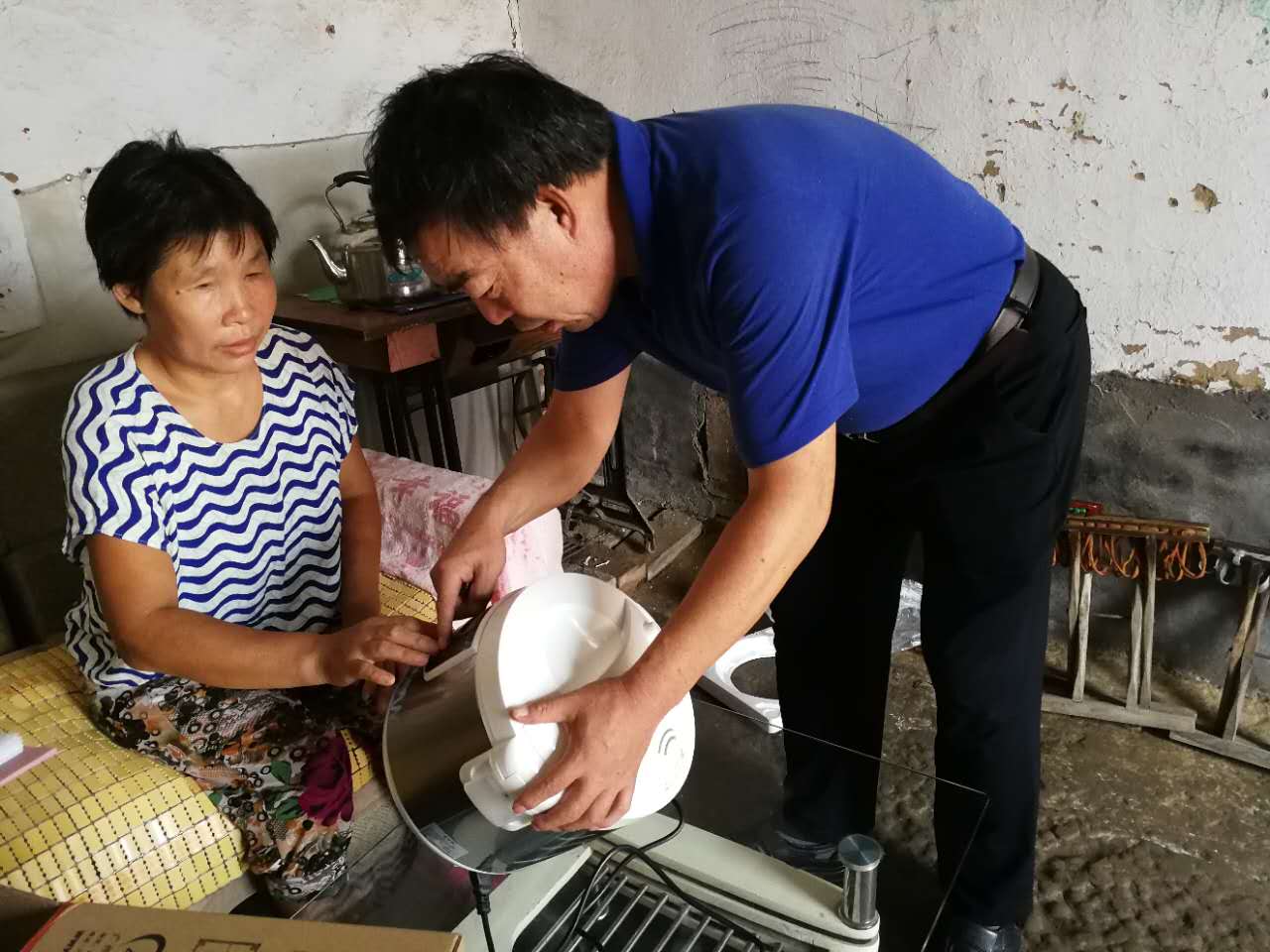 阳信县残联工作人员向残疾人讲解语音盲文电饭煲的用法